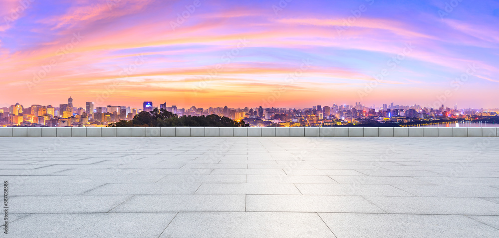 Wide square floor and city skyline with buildings in Hangzhou at sunrise.