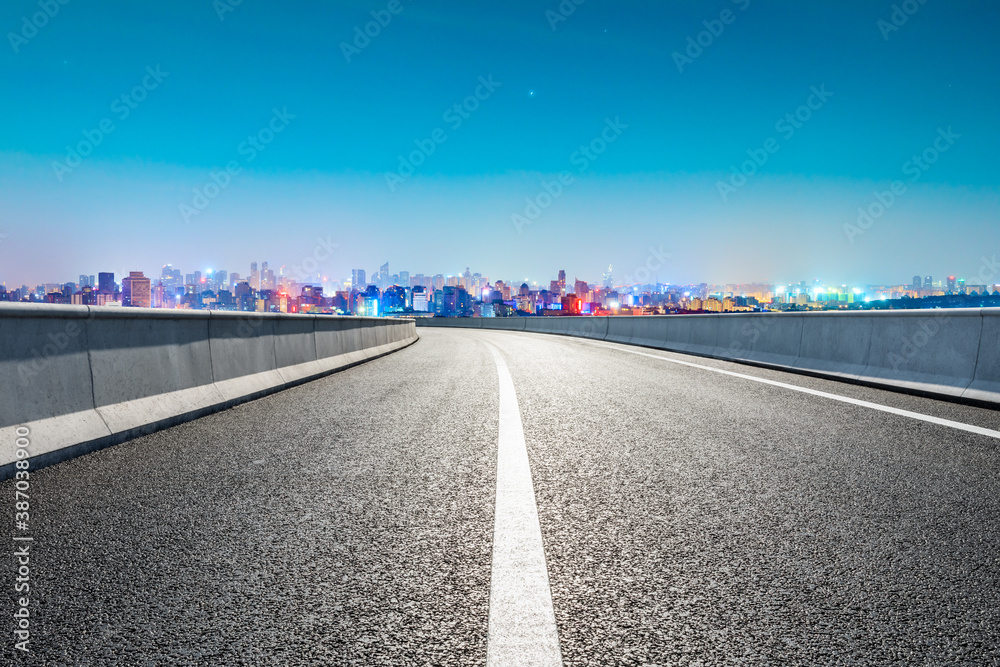 Empty asphalt road and city skyline with buildings in Hangzhou at night. Empty asphalt road and city skyline with buildings in Hangzhou at night.
