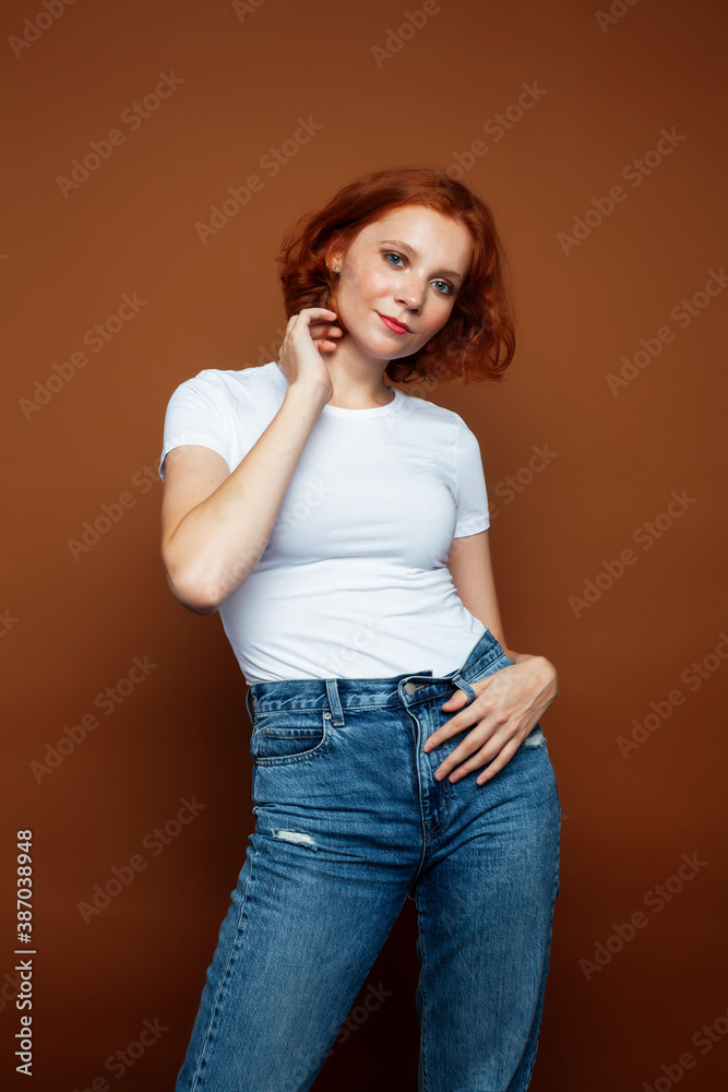 young pretty redhead girl posing cheerful on warm brown background, lifestyle people concept young pretty redhead girl posing cheerful on warm brown background, lifestyle people concept