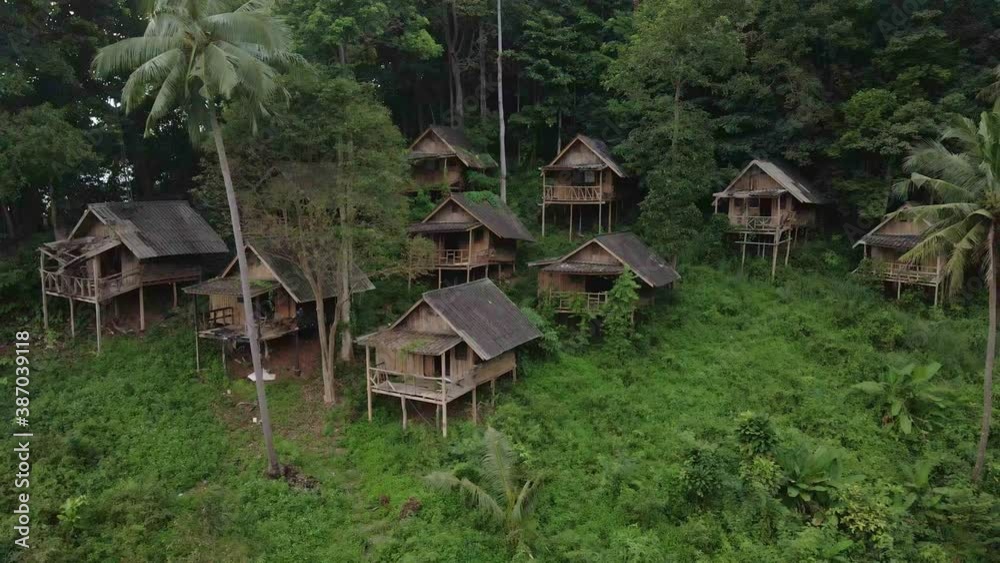 backwards dolly shot drone, aerial birds eye view of old backpacker style wooden bungalows in South east Asia that are now derelict and unused due to the effects of the pandemic on travel and tourism backwards dolly shot drone, aerial birds eye view of old backpacker style wooden bungalows in South east Asia that are now derelict and unused due to the effects of the pandemic on travel and tourism