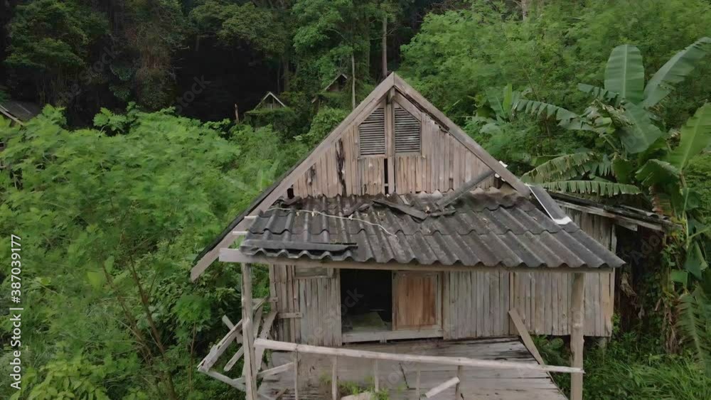 dolly shot droneflyes closely over old style wooden Thai bungalow that is now derelict and unused due to the effects of the pandemic on travel and tourism dolly shot droneflyes closely over old style wooden Thai bungalow that is now derelict and unused due to the effects of the pandemic on travel and tourism