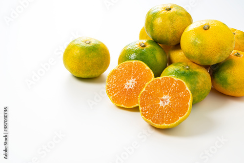 Early Japanese mandarin oranges on a white background