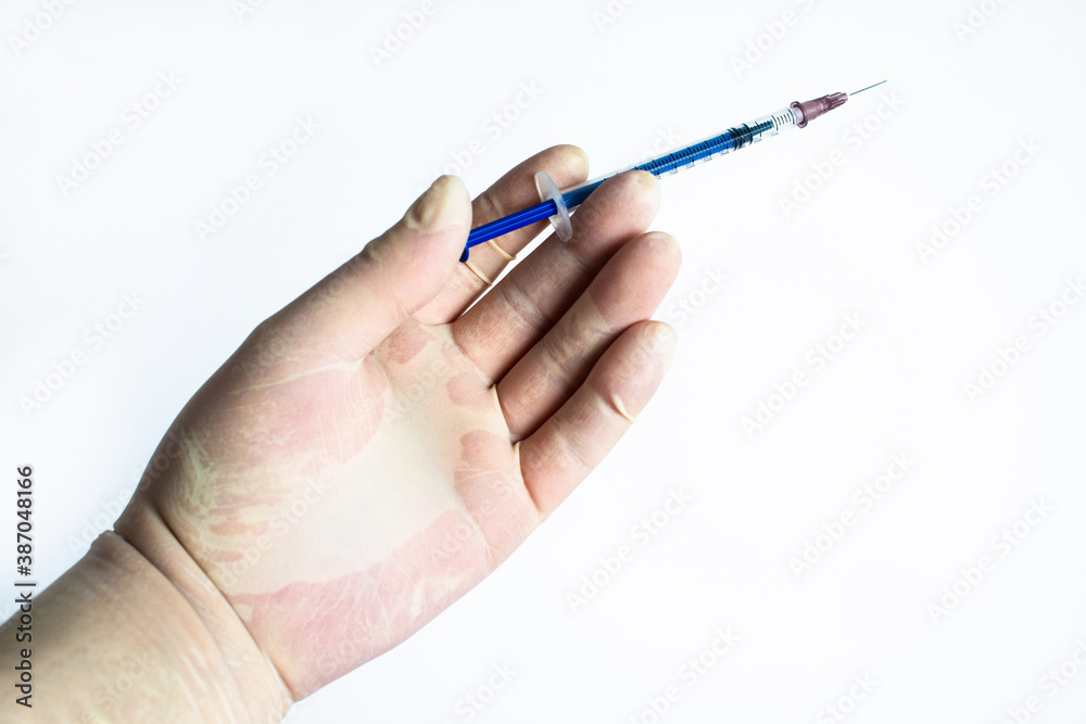 The hand holding the syringe.Isolated on a white background.