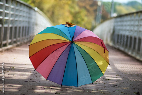 View of rainbow umbrella on the floor on modern bridge in autumn © pixarno