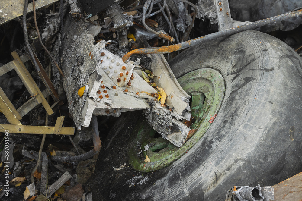 Plane wreckage, parts of the fuselage and landing gear with the wheel