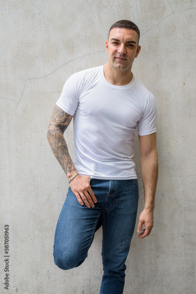 Portrait of handsome man with tattoos leaning against wall Portrait of handsome man with tattoos leaning against wall