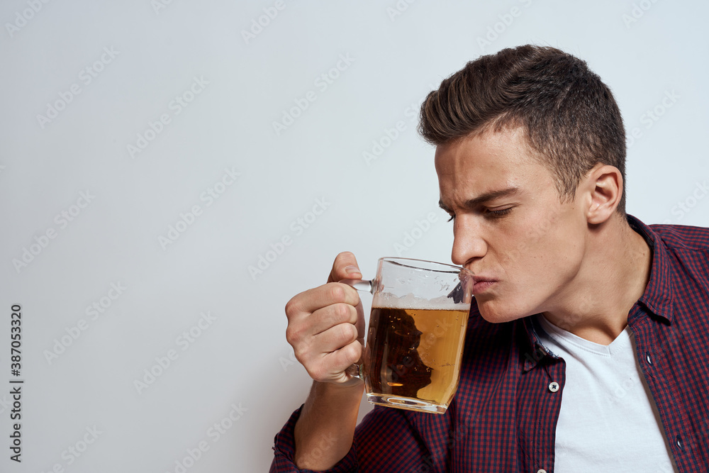 Drunk man with a mug of beer vacation alcohol lifestyle in a red shirt emotions light background Drunk man with a mug of beer vacation alcohol lifestyle in a red shirt emotions light background