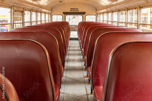 Aisle of a large school bus with red seats landscape