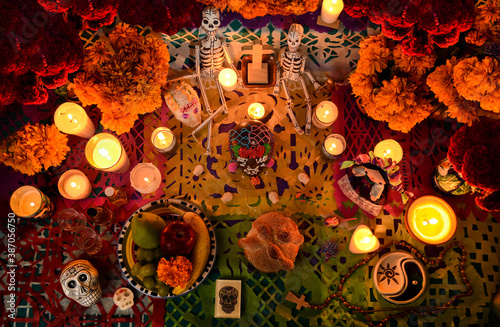 Mexican day of the dead altar at night in dim candlelight