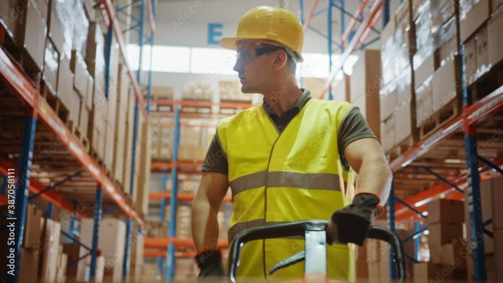 Worker Moves Cardboard Boxes using Hand Pallet Truck, Walking between Rows of Shelves with Goods in Retail Warehouse. People Work in Product Distribution Logistics Center. Point of View Shot