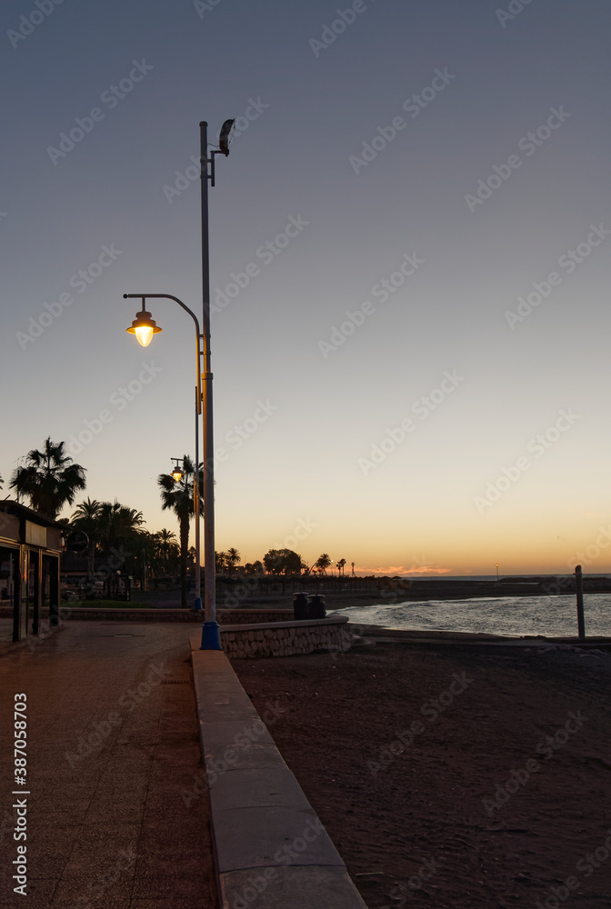 view of the sea and Lamppost on the Pedregalejo Beach at dusk
