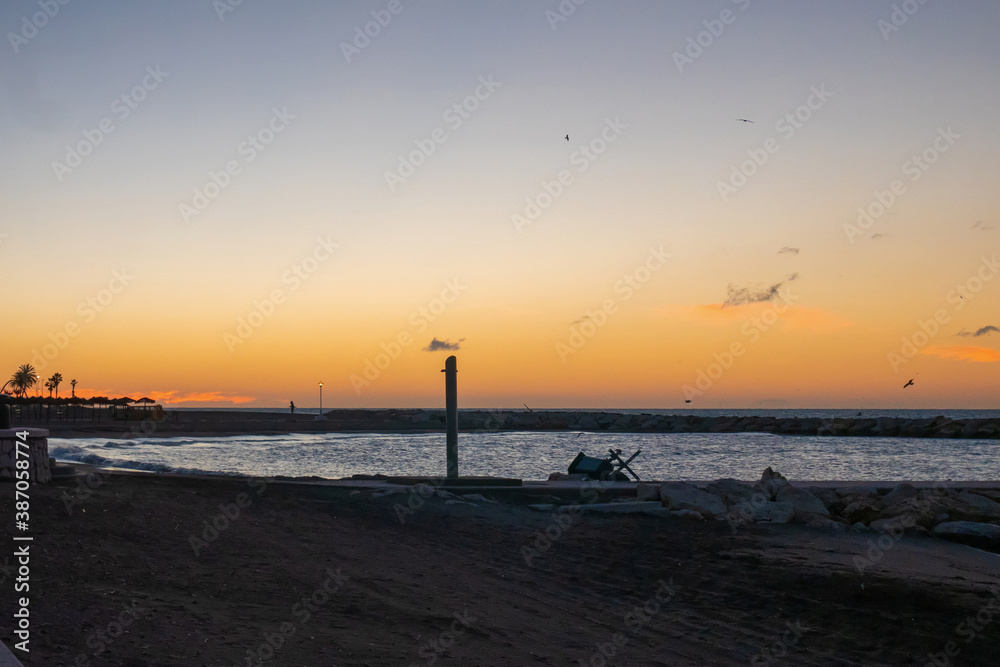 view of the sea and stones on the Pedregalejo Beach at dusk