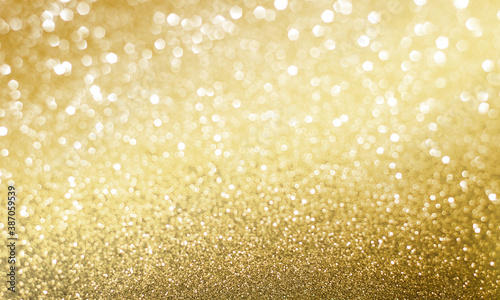 Golden sparkle glitters with bokeh effect and selectieve focus. Festive background with bright gold lights, champagne bubble. Christmas mood concept. Copy space, close up, texture, top view. © WEERASAK