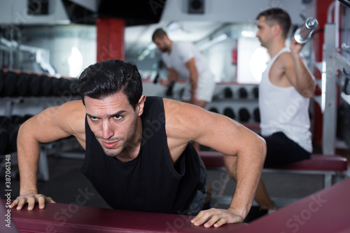 Muscular man practicing healthy lifestyle, performing push-ups during training