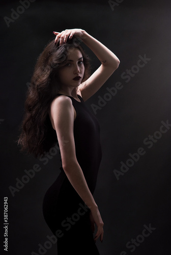 Silhouette of a beautiful, slender brunette in a black dress