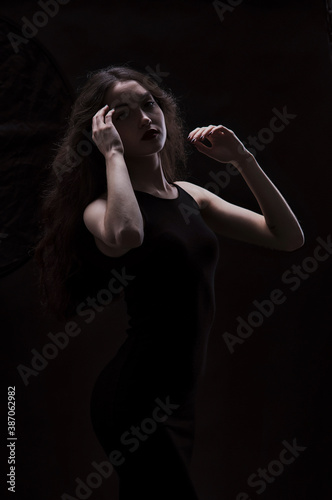 Silhouette of a beautiful  slender brunette in a black dress