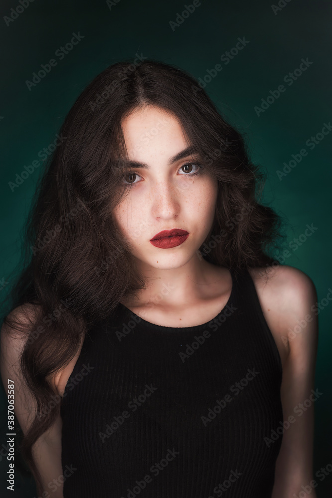 Portrait of a young brunette with lush wavy hair and beautiful highlights in the eyes Portrait of a young brunette with lush wavy hair and beautiful highlights in the eyes