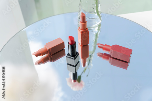 Set of cosmetic lipstics collection on mirror surface. photo