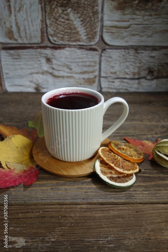 Hot fruit tea with lemon on a wooden background. Selective focus.Still life, food and drink, seasonal  concept.
