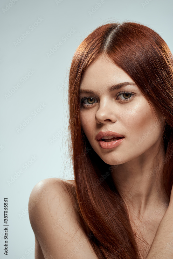 pretty redhead woman holding her hair with hands grooming naked shoulders light background pretty redhead woman holding her hair with hands grooming naked shoulders light background