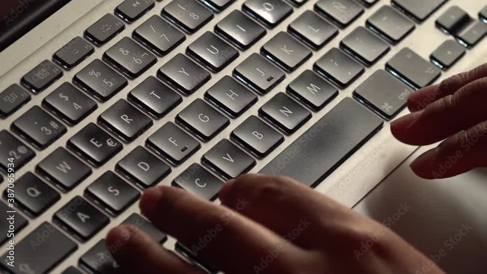Close up of female hands typing on a laptop keyboard.