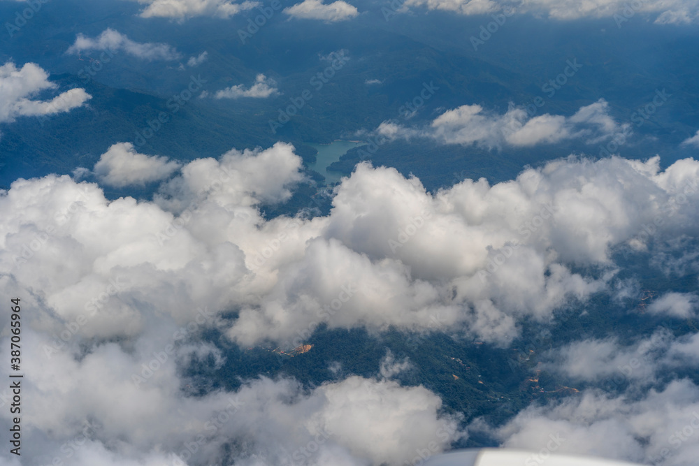 Naklejka premium Flying above the earth and above the clouds in territory Kota Kinabalu, island Borneo, Malaysia. Airplane window view.