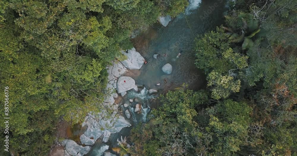 Drone aerial bird's-eye view of people swimming on a river in the middle of a forest in Colombia Drone aerial bird's-eye view of people swimming on a river in the middle of a forest in Colombia