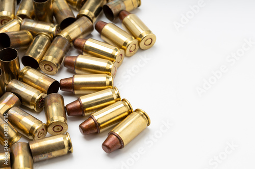 A pile of .45 bullets and bullet shells on white background