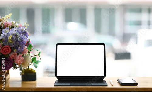 Worktable with mock up digital tablet and smart phone in co working space.