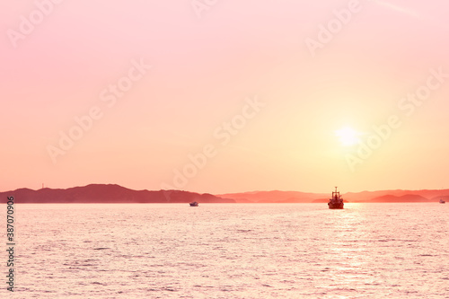 Peace pink ocean view with rock mountain, cliff, open water and island in a quiet afternoon sunset in Japan, Seto Inland sea.