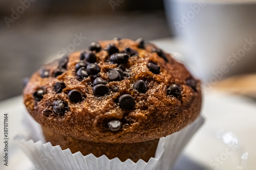 Cup cake topping with shocolate and Nuts on the white plate in a cafe during coffee break. photo