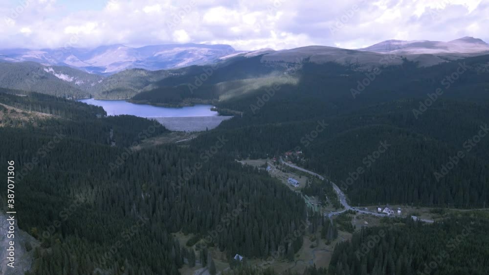 High drone view of mountains with a trail going to a lake 4K High drone view of mountains with a trail going to a lake 4K