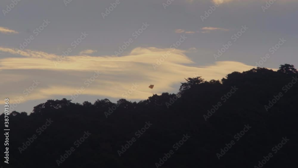 kite flying in the heavy wind between mountain and clouds orange sunrise kite flying in the heavy wind between mountain and clouds orange sunrise
