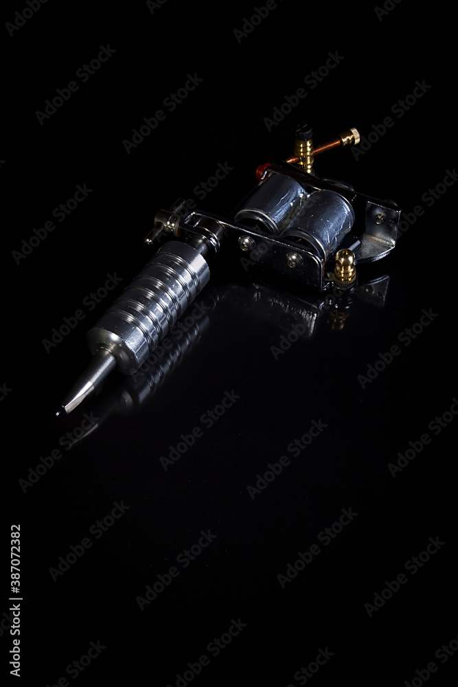 Naklejka premium Tattoo machine on black surface