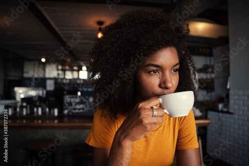 Ethnic female sipping hot coffee relaxing in rustic restaurant  photo