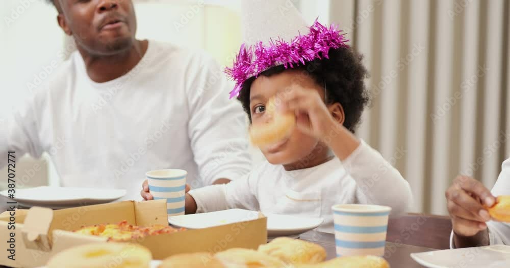 Little boy enjoy meal with his family at home. Happy family celebrating together at home. Little boy enjoy meal with his family at home. Happy family celebrating together at home.