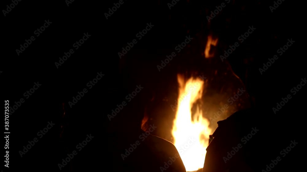 People sit by the fire at night. The concept of walking and recreation in nature, background, tourism People sit by the fire at night. The concept of walking and recreation in nature, background, tourism