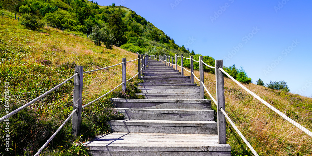 wooden walking pathway in puy-de-dome french mountain chain volcano in summer day