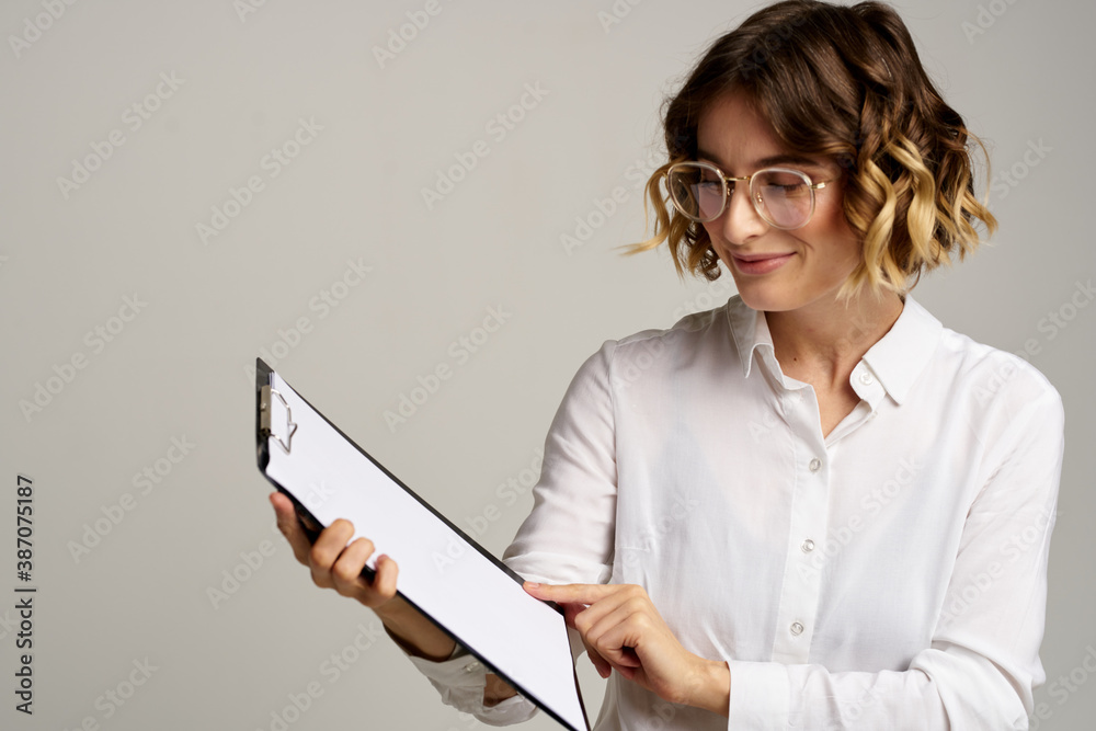 Business woman with folder of documents in hands on gray background cropped view of work Business woman with folder of documents in hands on gray background cropped view of work