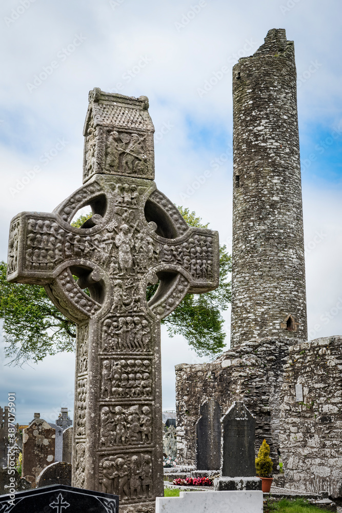 Drogheda, Ireland - July 15, 2020: View of Muiredach's high celtic cross and round tower at early Christian monastic settlement Monasterboice founded in 5th century.