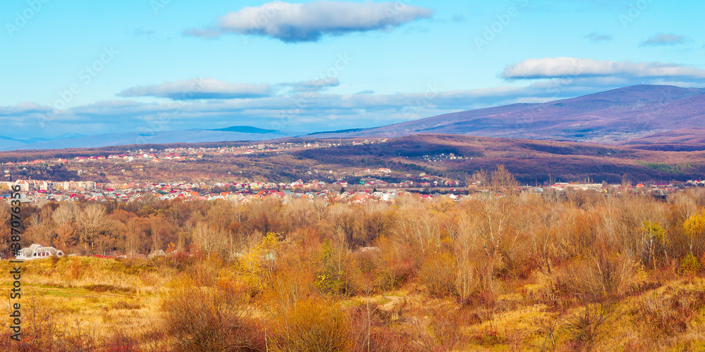 rural valley in the morning. beautiful autumn scenery in mountains. town in the distant valley. clouds on the blue forenoon sky