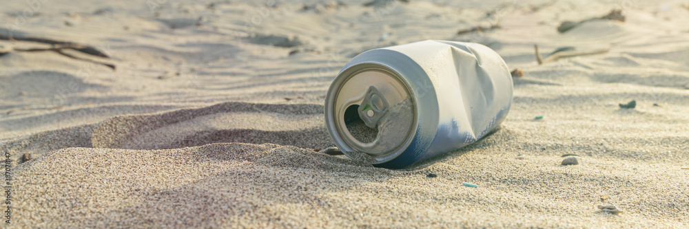 Aluminium can left on sand of beach. Garbage polluting the natural environment and pollution Aluminium can left on sand of beach. Garbage polluting the natural environment and pollution