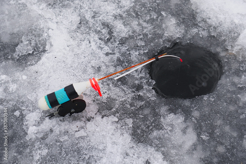 Winter fishing rod at the drilled hole catches fish. Ice fishing
