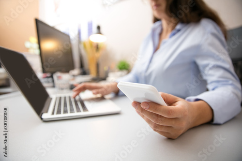 Close up of female hands with devices. Remote working from home. Workplace in home office with PC  gadgets. Concept of distance learning  isolation  female business  shopping online  conference.