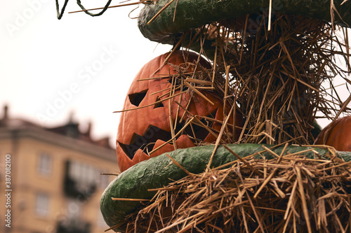 Halloween pumpkin head jack. Decorative pumpkins at farm market stands on sheaves of hay .Thanksgiving holiday season and Halloween decor