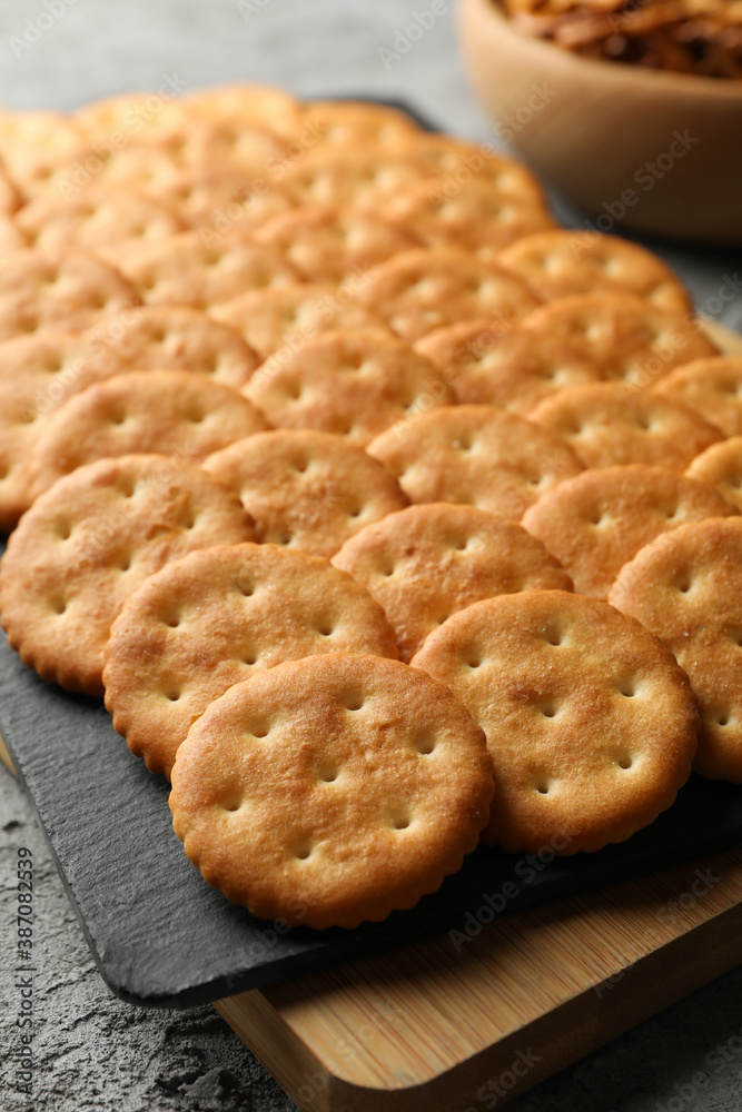 Board with cracker biscuits on gray background Board with cracker biscuits on gray background