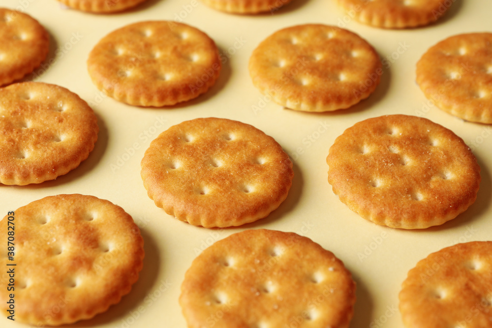 Tasty cracker biscuits on beige background, close up