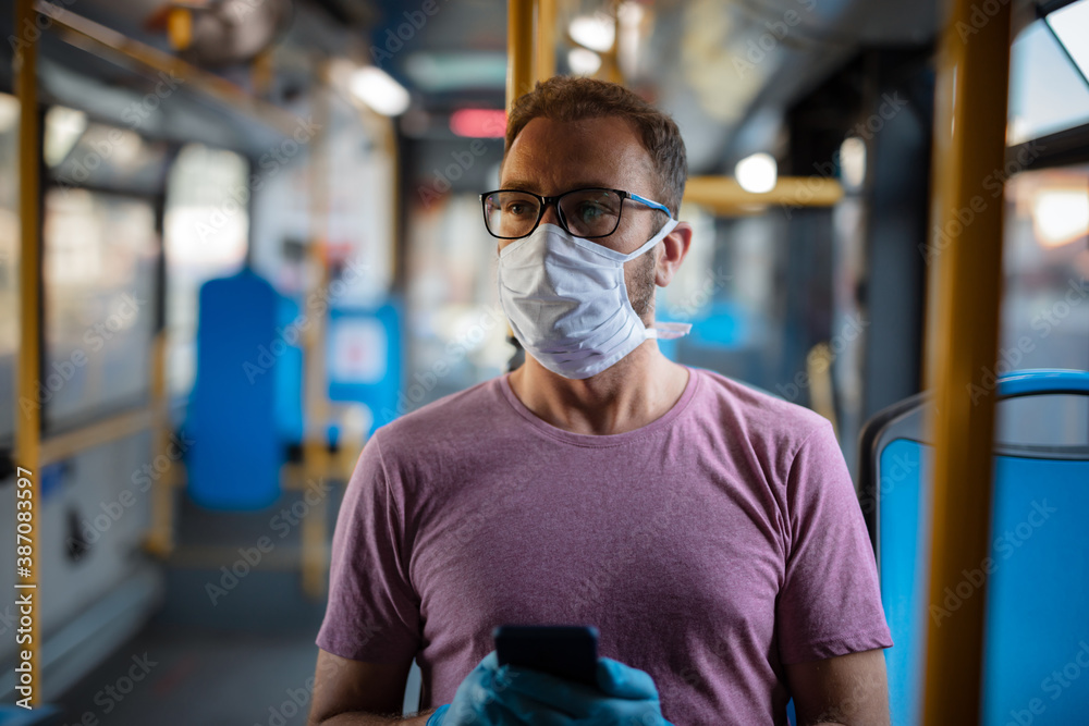 Man with medical protective mask and gloves sitting in an emtpy bus. Man with medical protective mask and gloves sitting in an emtpy bus.
