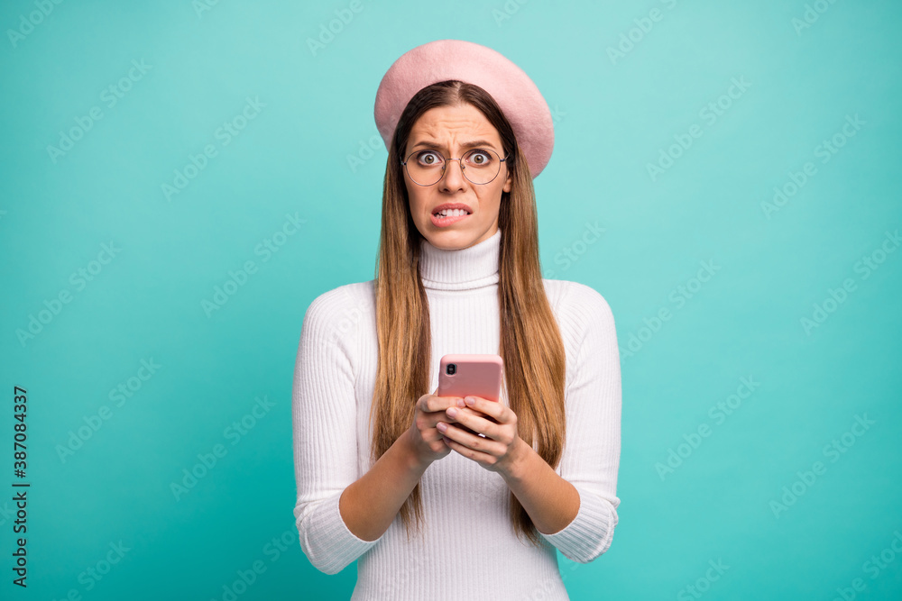 Photo of pretty terrified lady hold telephone read new post negative comments biting lips wear specs modern pink beret cap white turtleneck isolated bright teal color background Photo of pretty terrified lady hold telephone read new post negative comments biting lips wear specs modern pink beret cap white turtleneck isolated bright teal color background