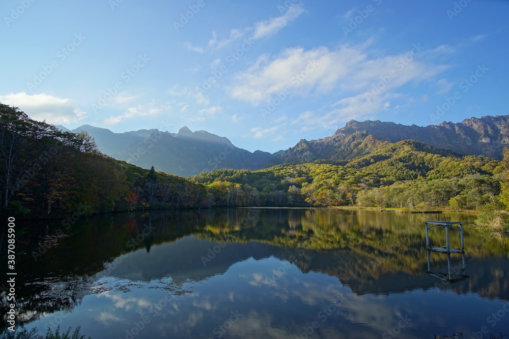 A pond that reflects trees and mountains like a mirror. At dusk. Beautiful scenery of Japan.